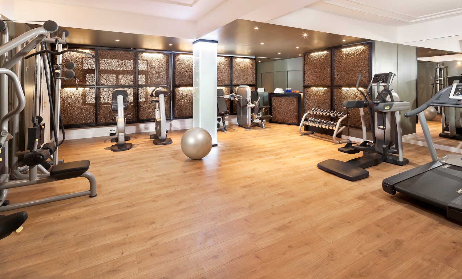 a room with exercise equipment and a wood floor