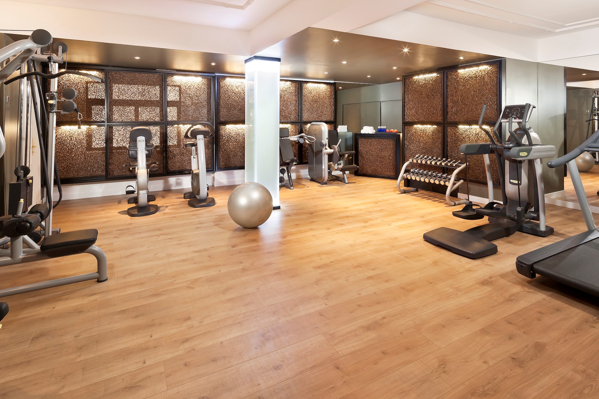 a room with exercise equipment and a wood floor