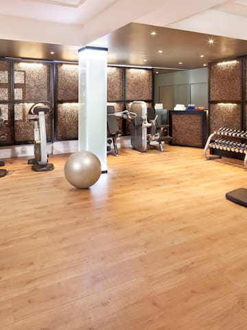 a room with exercise equipment and a wood floor