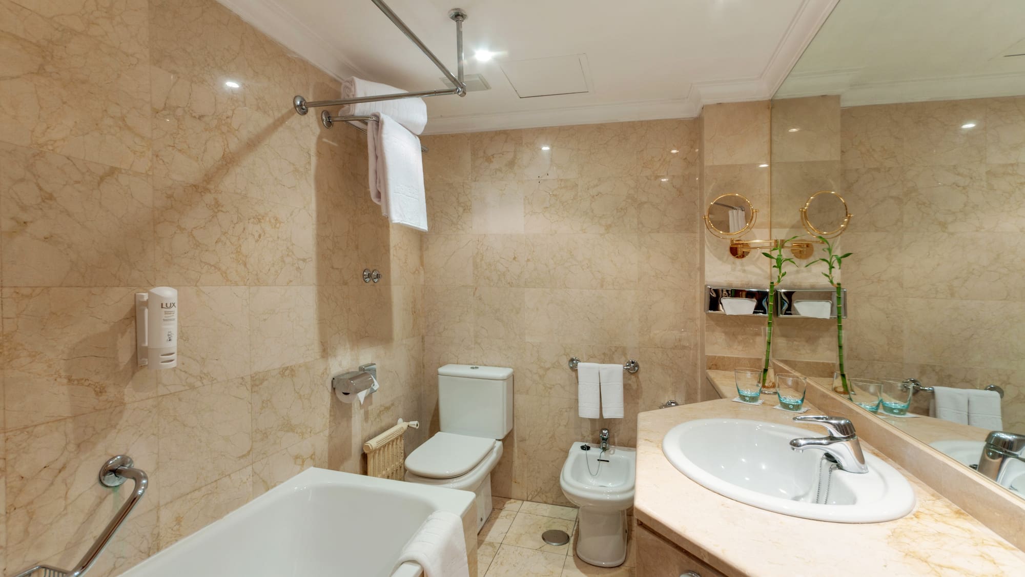 a bathroom with marble walls and a sink and toilet