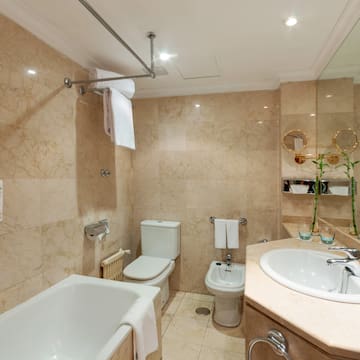 a bathroom with marble walls and a sink and toilet