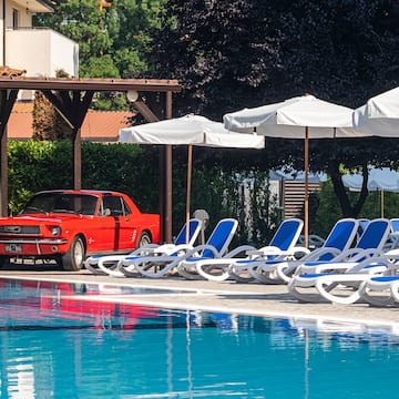 a red car parked next to a pool