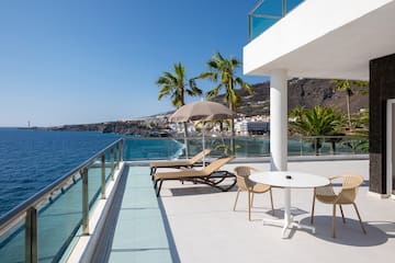 a deck with chairs and umbrellas overlooking the ocean