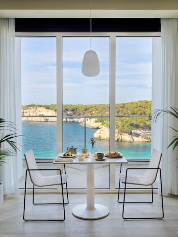 a table with food and chairs in front of a large window