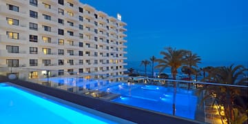 ein Pool mit Gebäude und Palmen