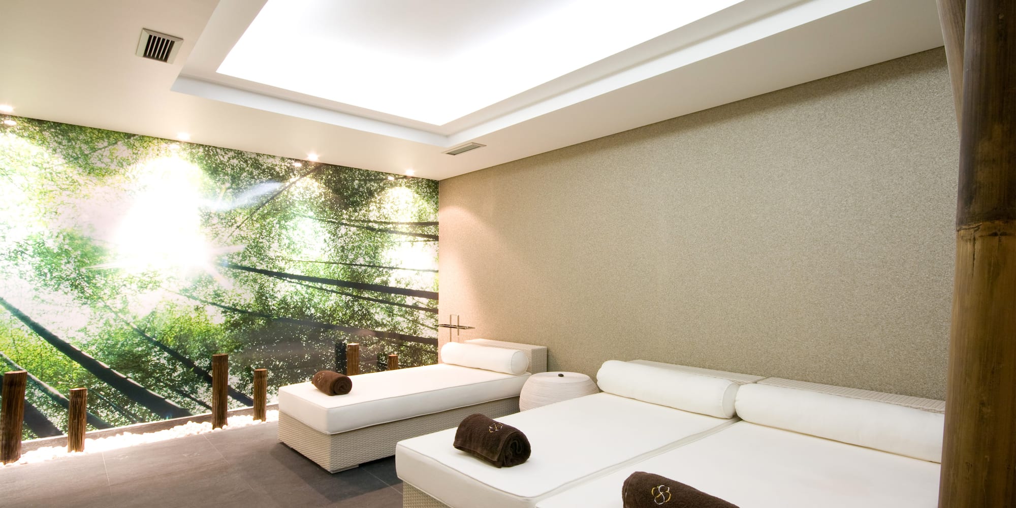 a room with white beds and a large window.