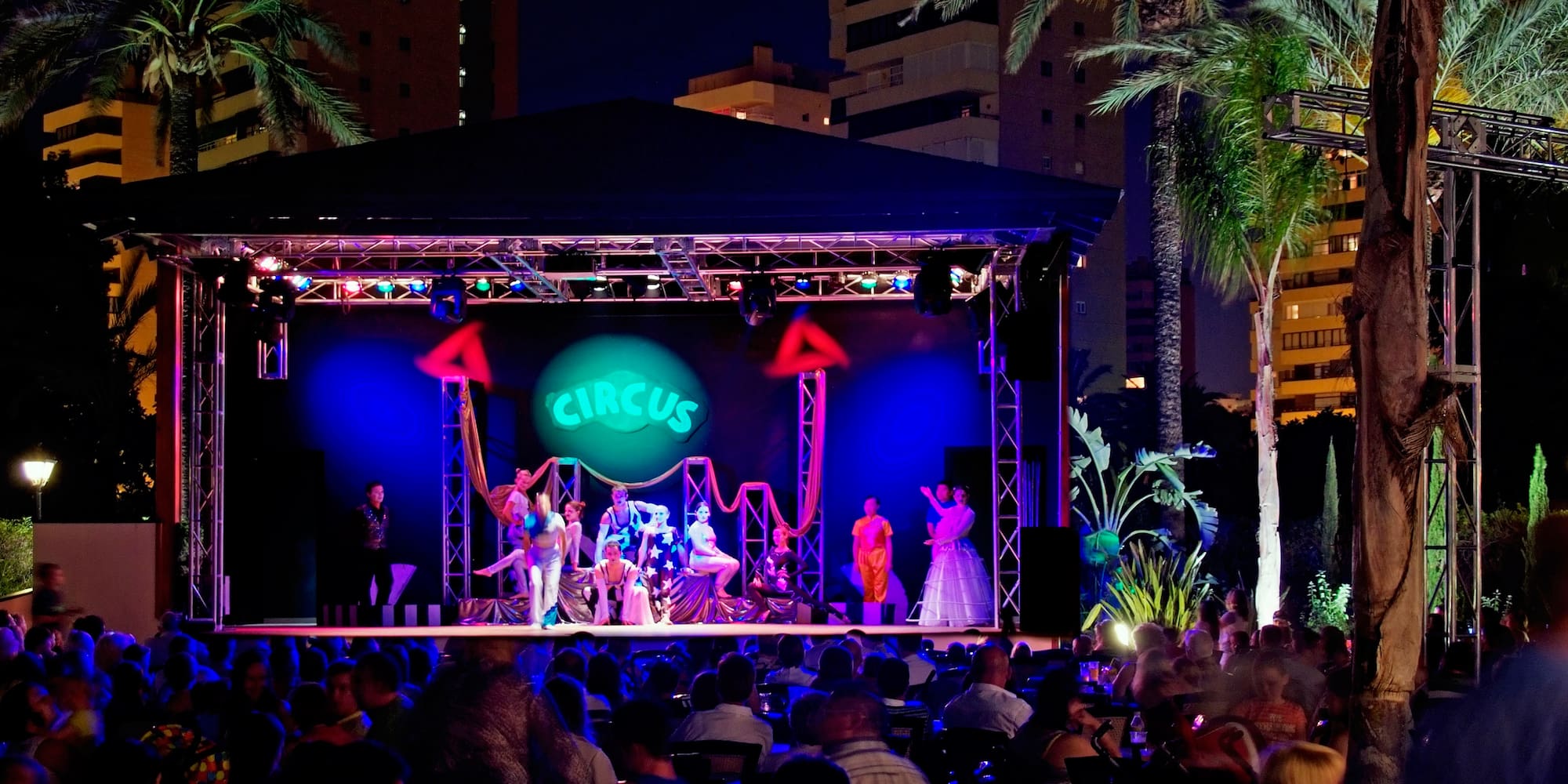 a group of people on a stage with a crowd of people watching