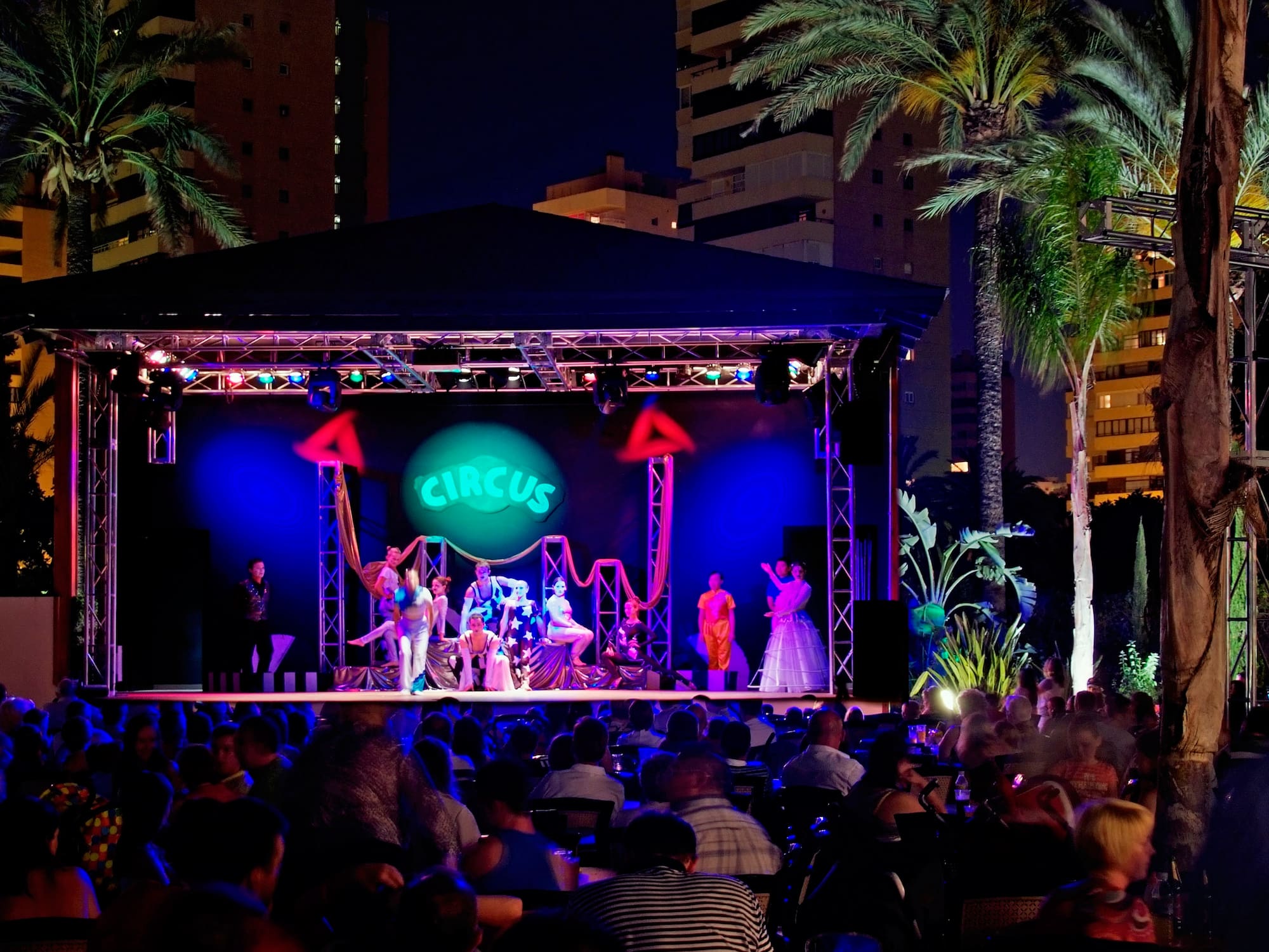 a group of people on a stage with a crowd of people watching