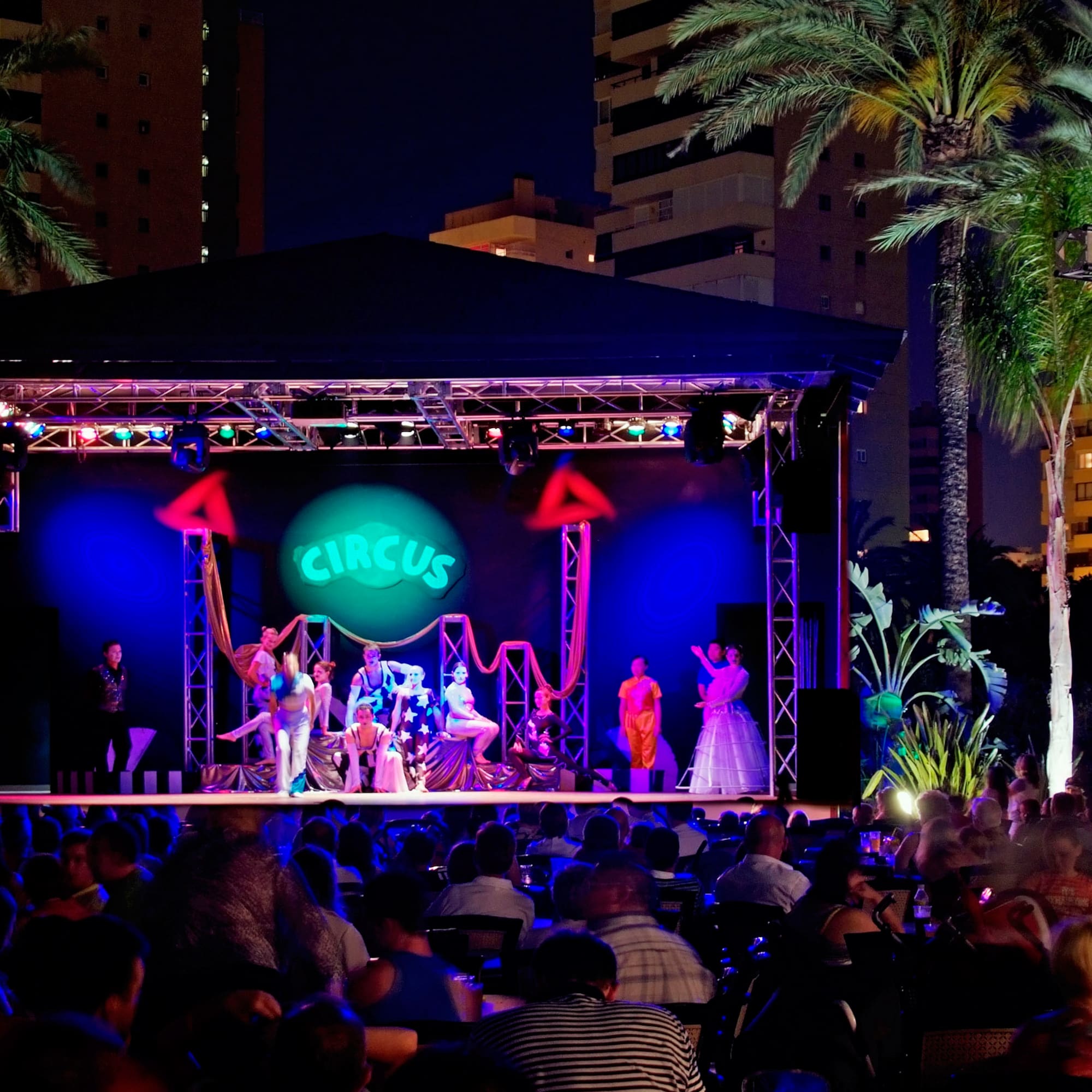 a group of people on a stage with a crowd of people watching