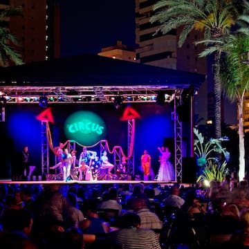 a group of people on a stage with a crowd of people watching