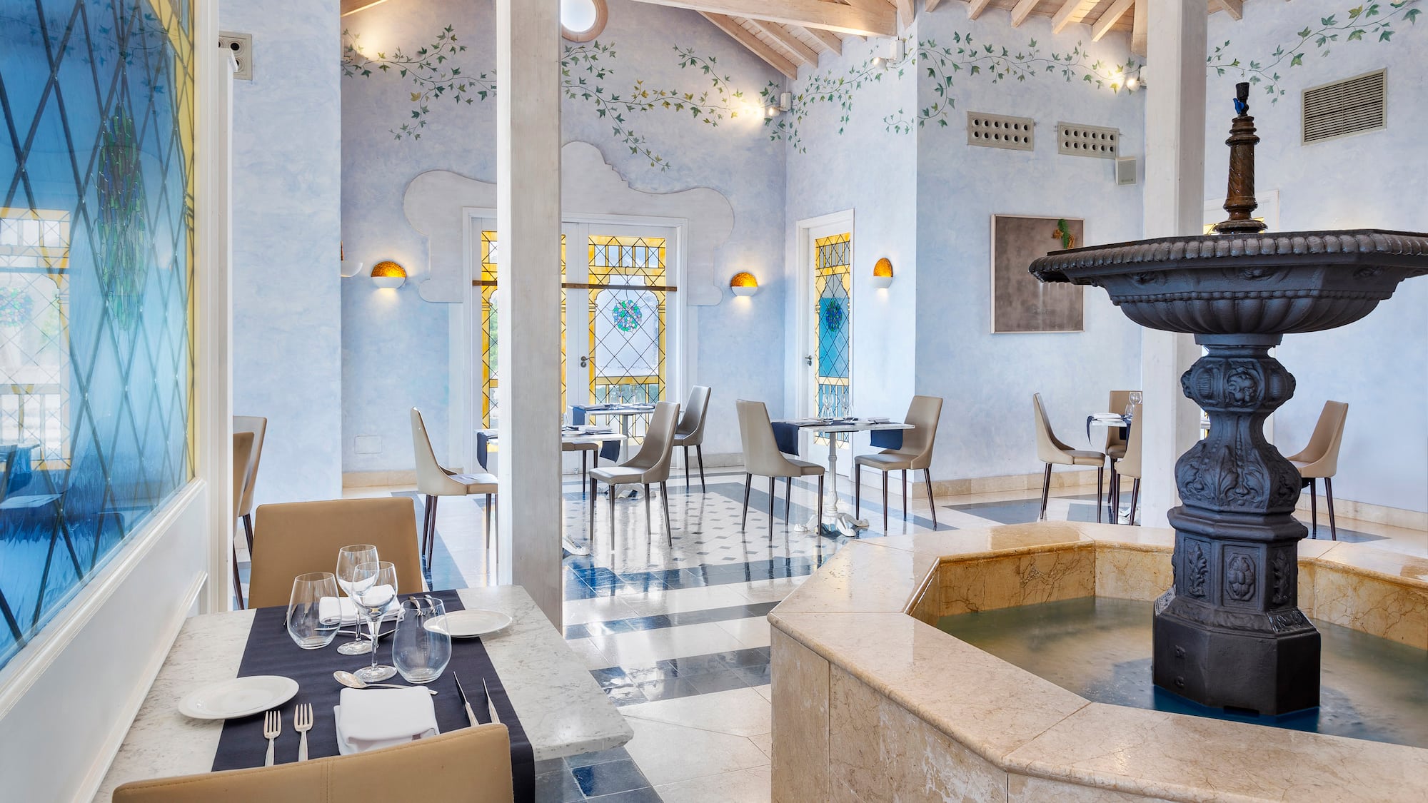 a room with a fountain and tables and chairs