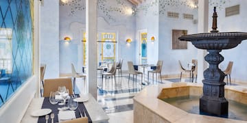 a room with a fountain and tables and chairs