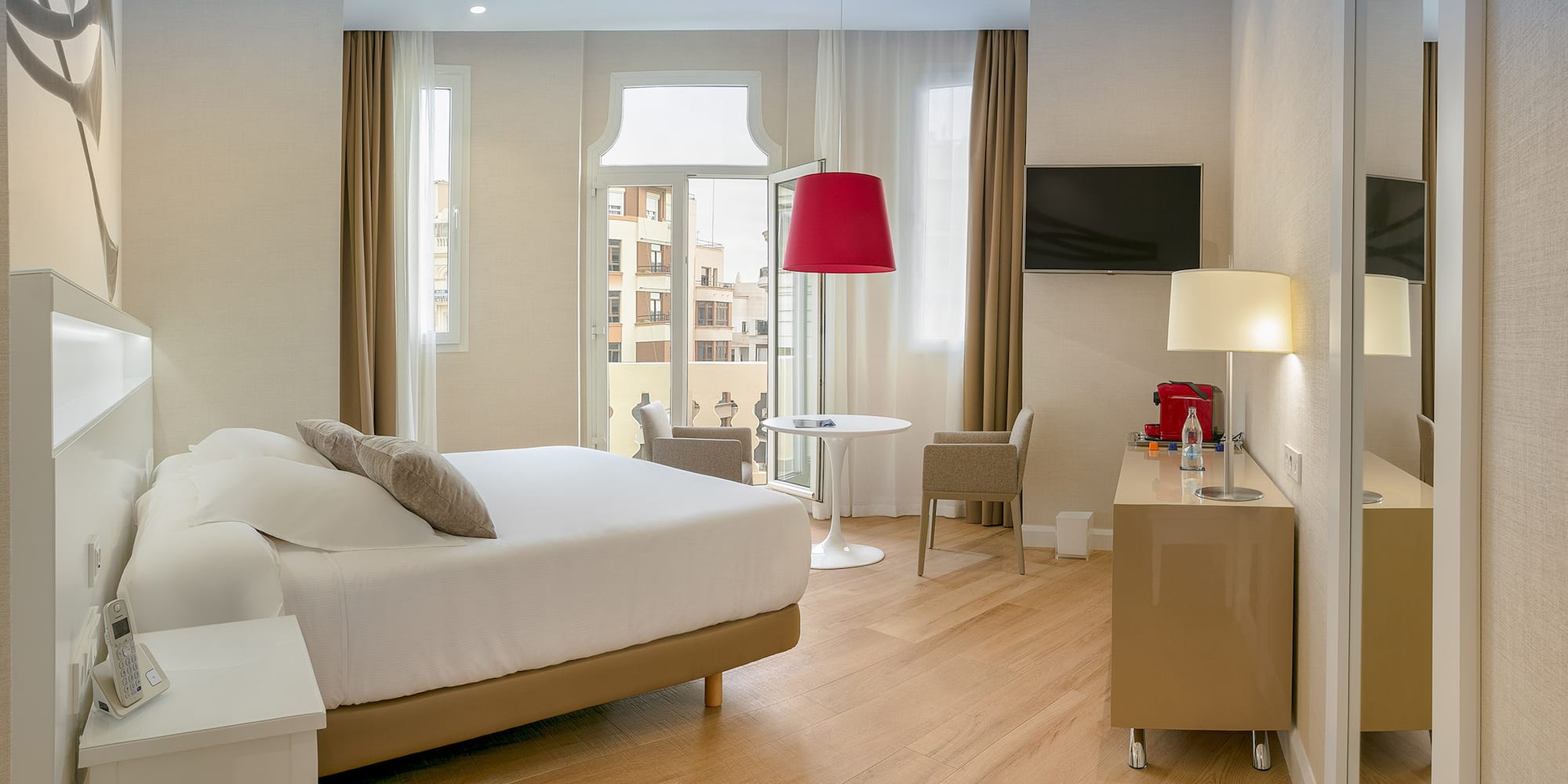 a room with a bed and a table and chairs