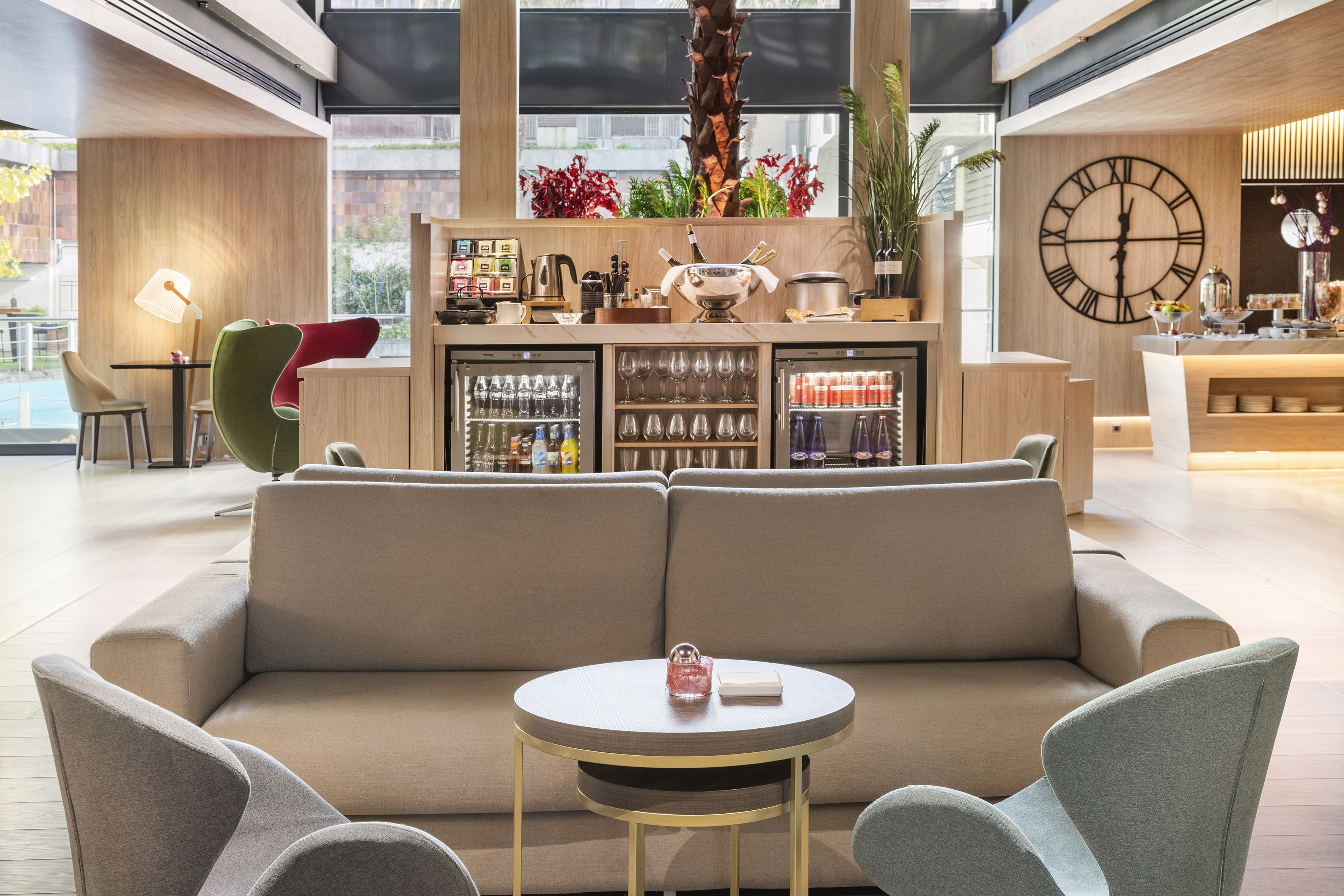 Modern hotel lounge with comfortable seating and refreshment bar.