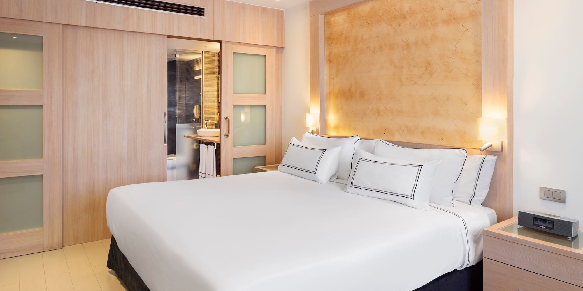 a bed with white sheets and pillows