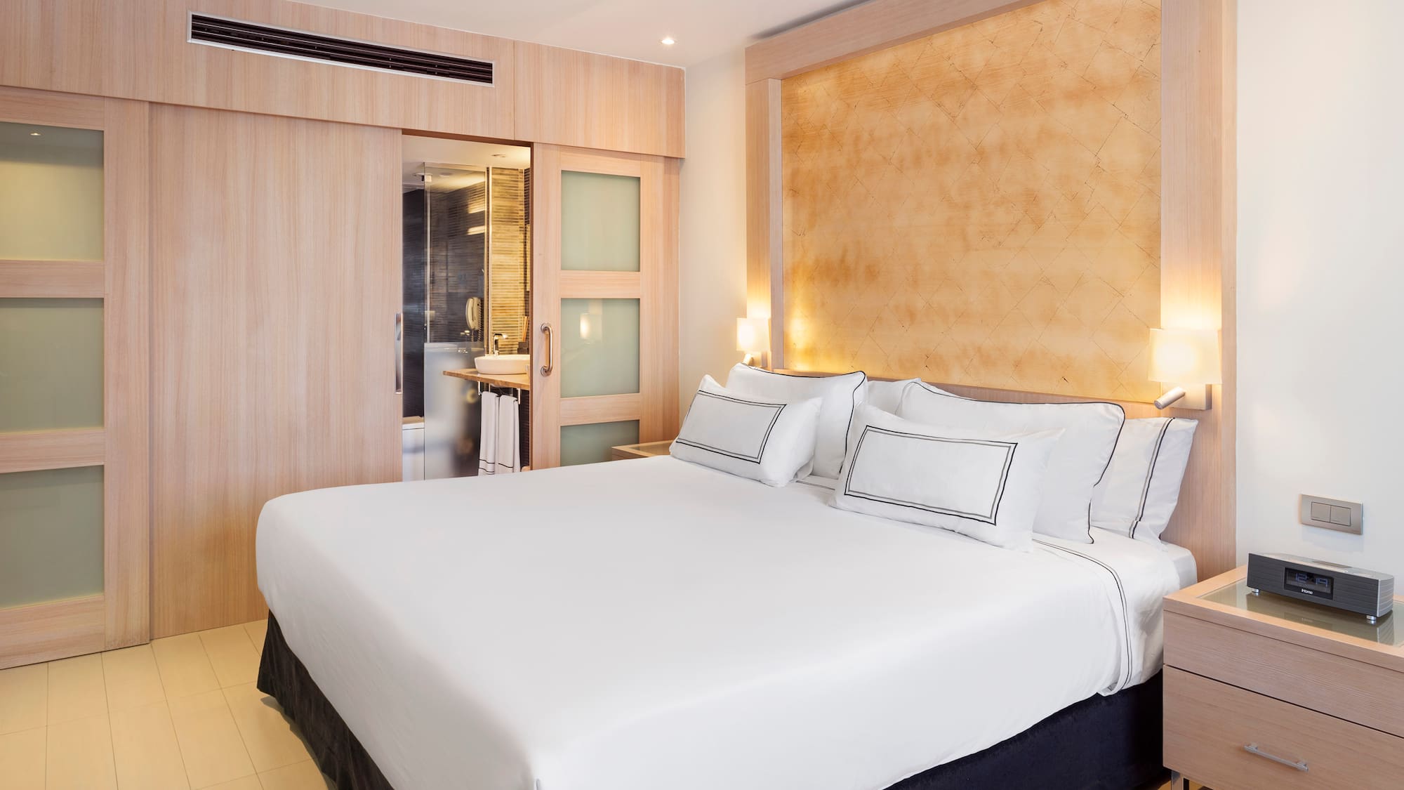 a bed with white sheets and pillows