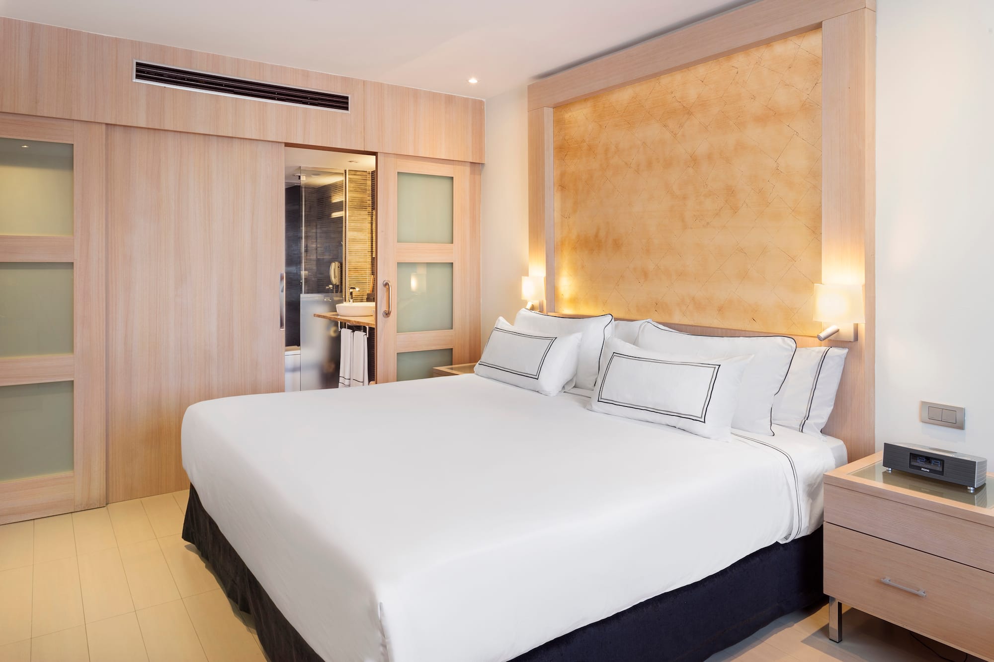 a bed with white sheets and pillows