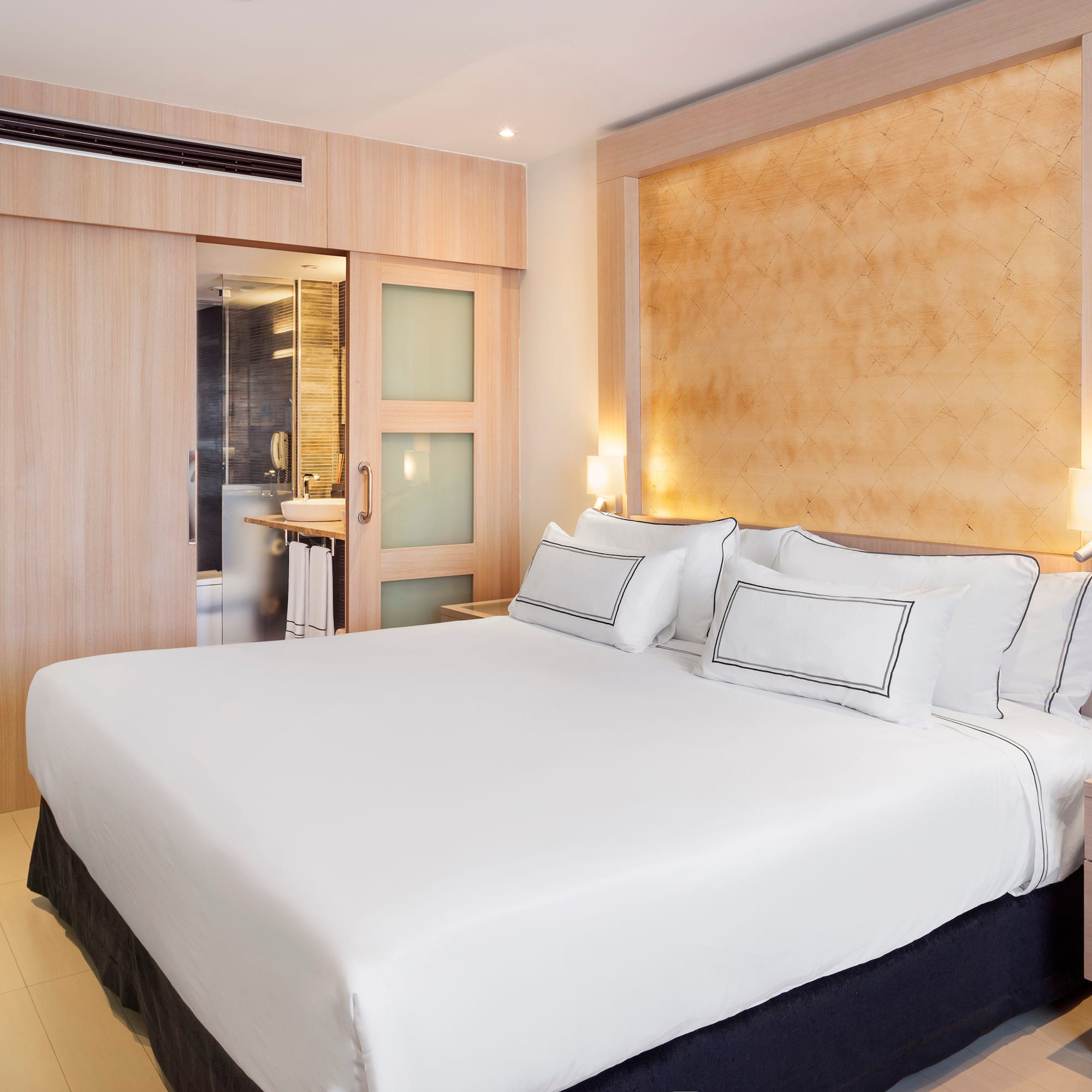 a bed with white sheets and pillows