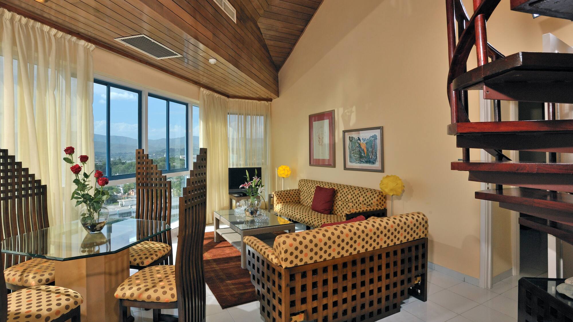 a living room with a spiral staircase and a couch and chairs