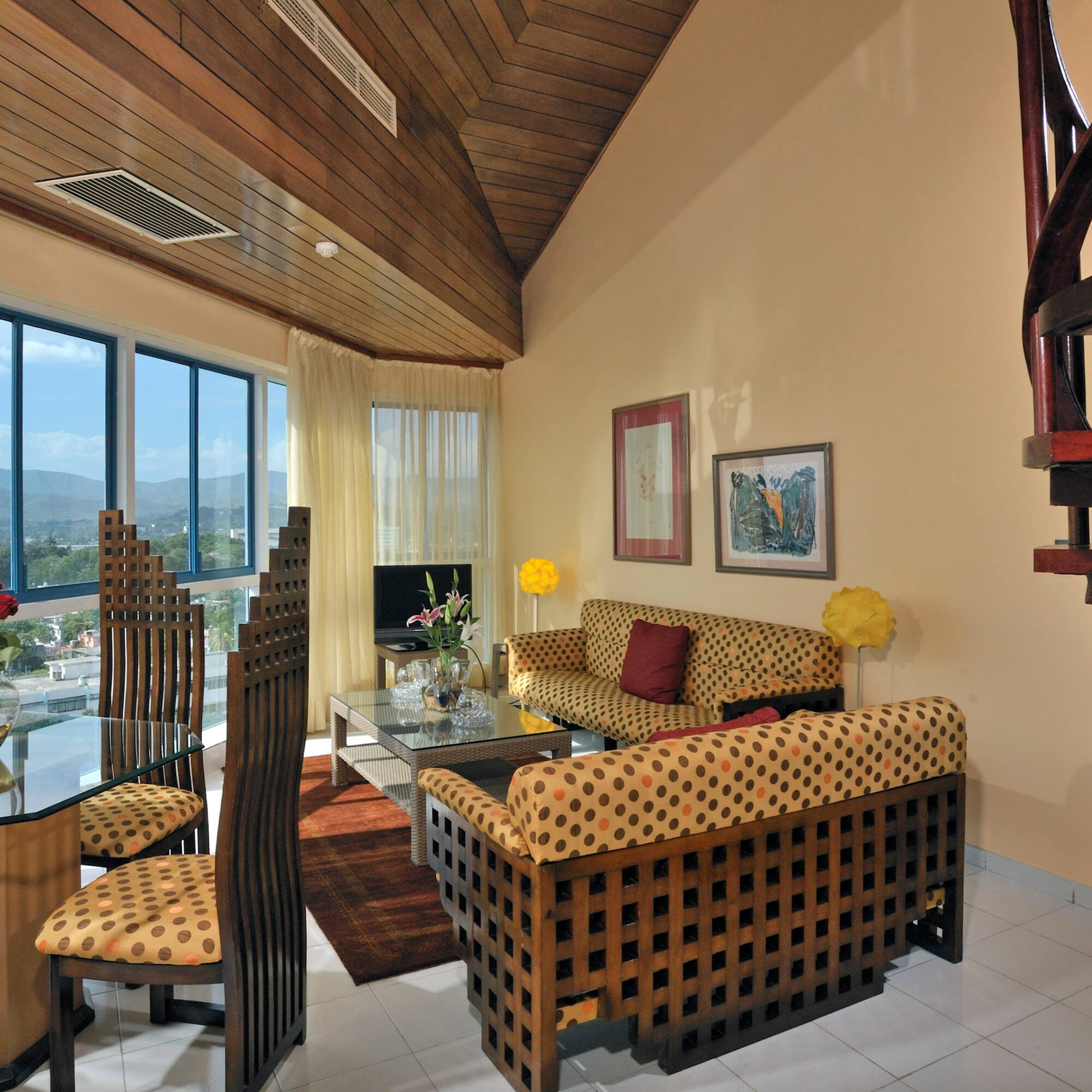 a living room with a spiral staircase and a couch and chairs