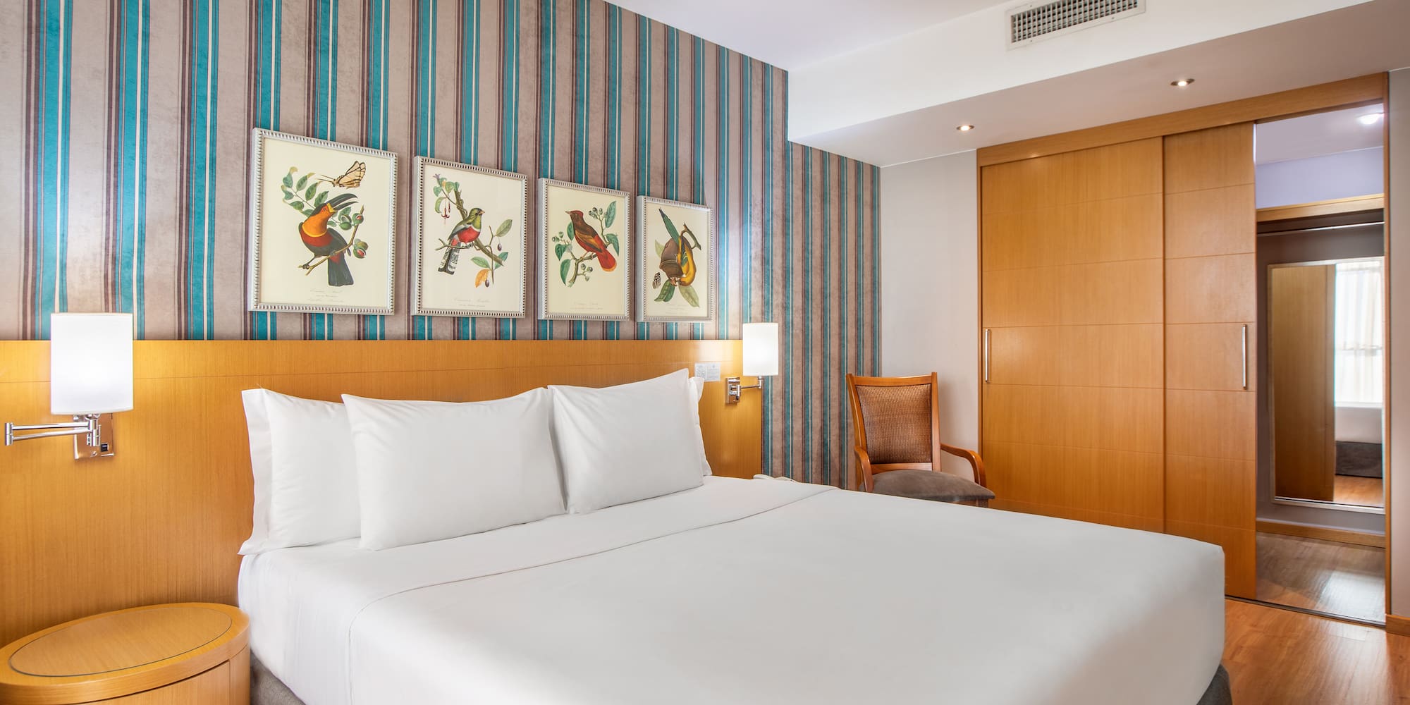 a bed with white sheets and a wood headboard in a hotel room