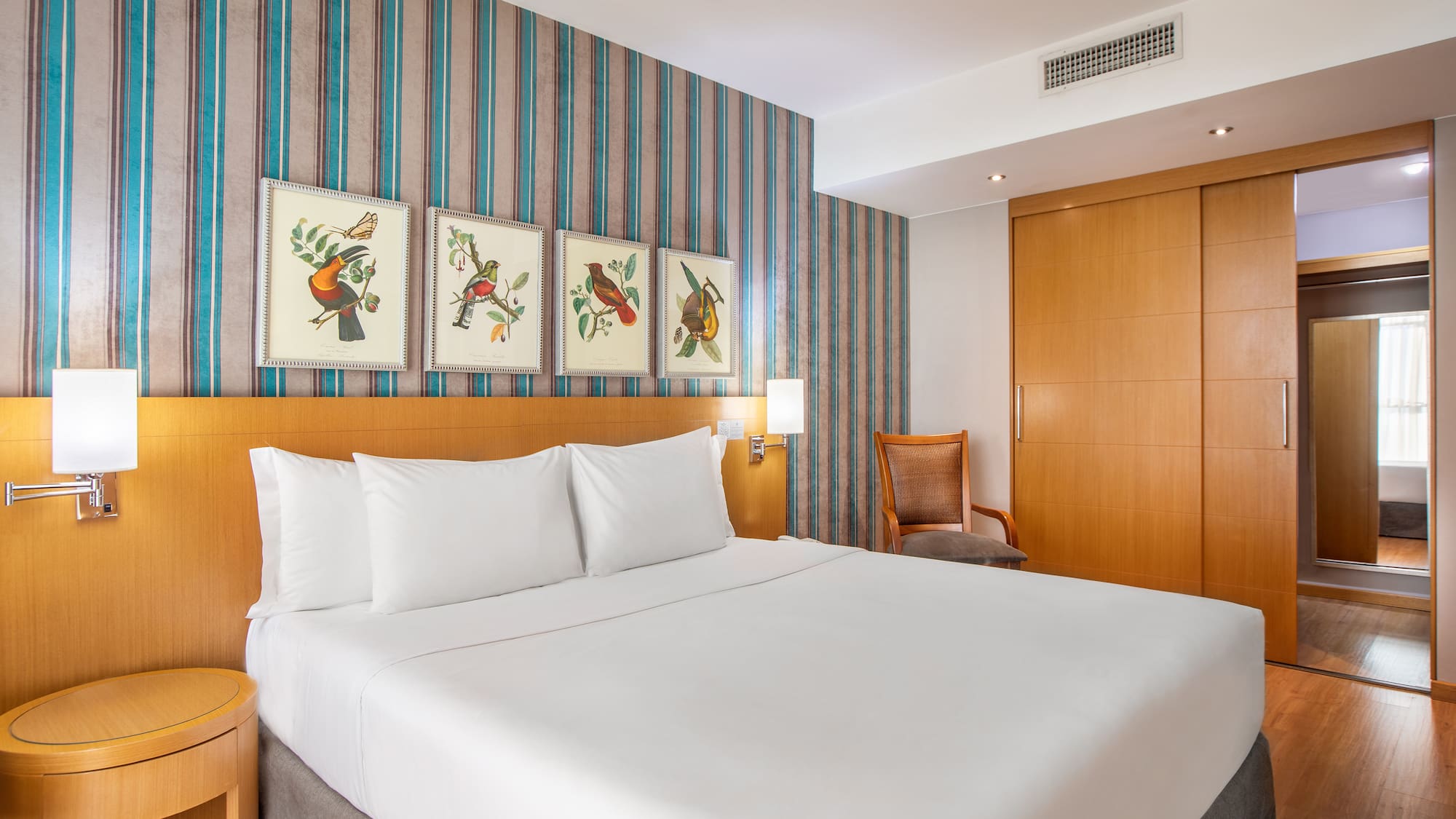 a bed with white sheets and a wood headboard in a hotel room