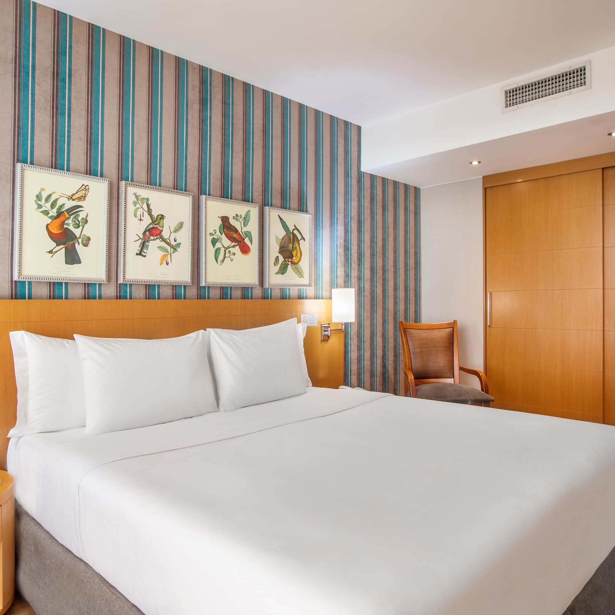 a bed with white sheets and a wood headboard in a hotel room