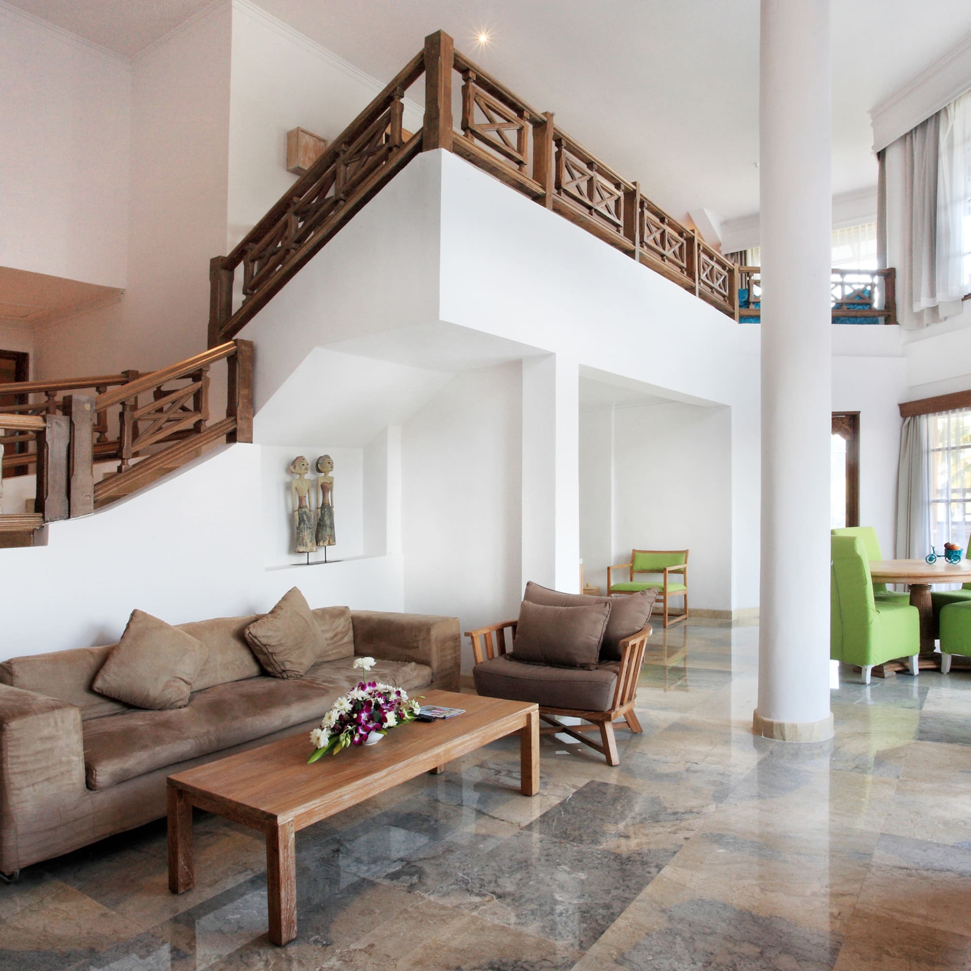 a living room with a staircase and couches