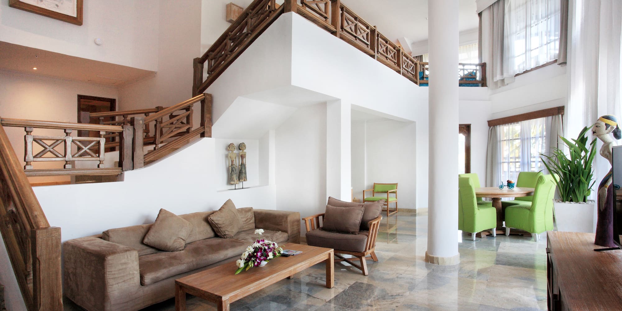 a living room with a staircase and couches