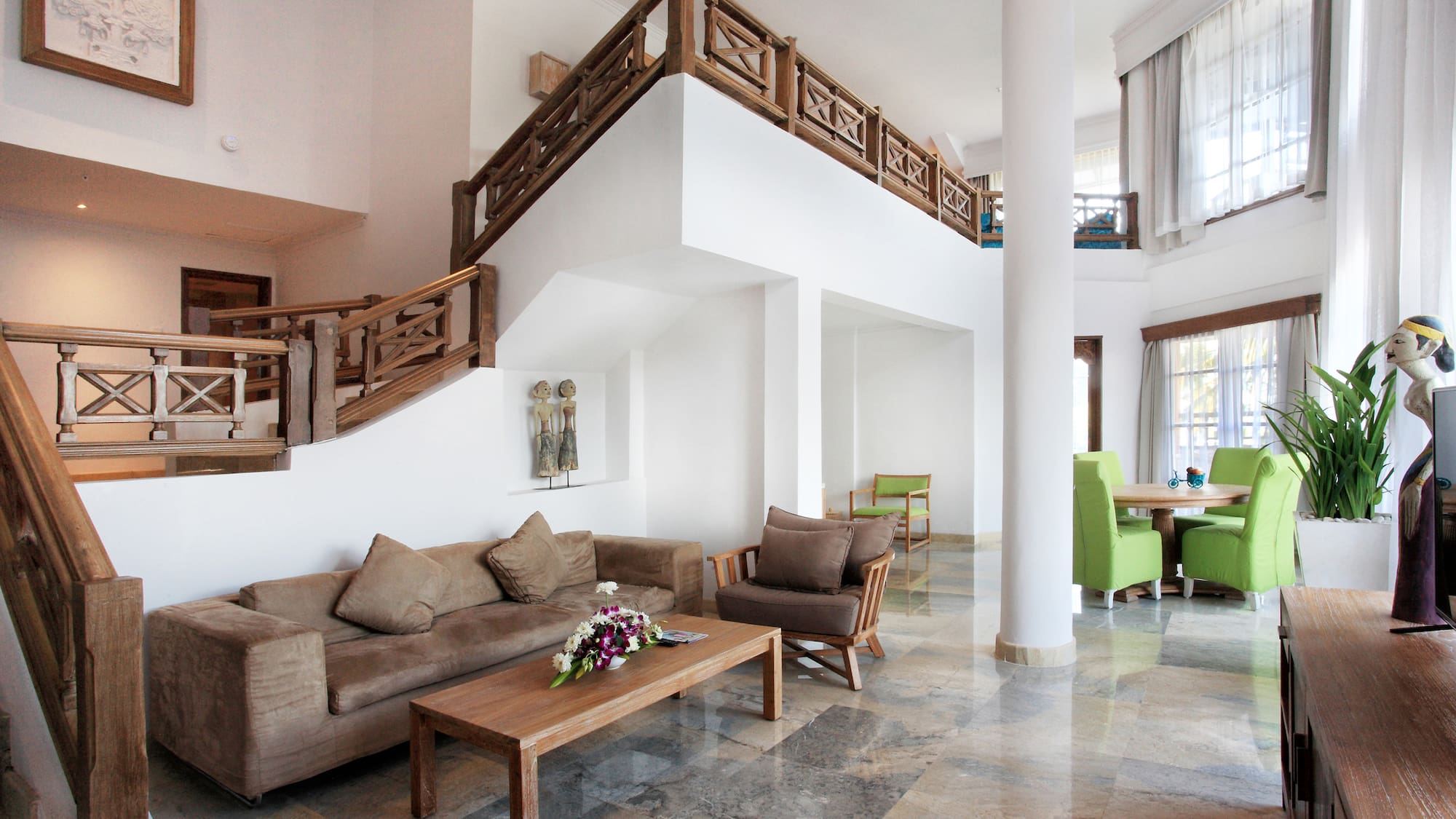 a living room with a staircase and couches