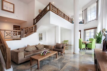 a living room with a staircase and couches