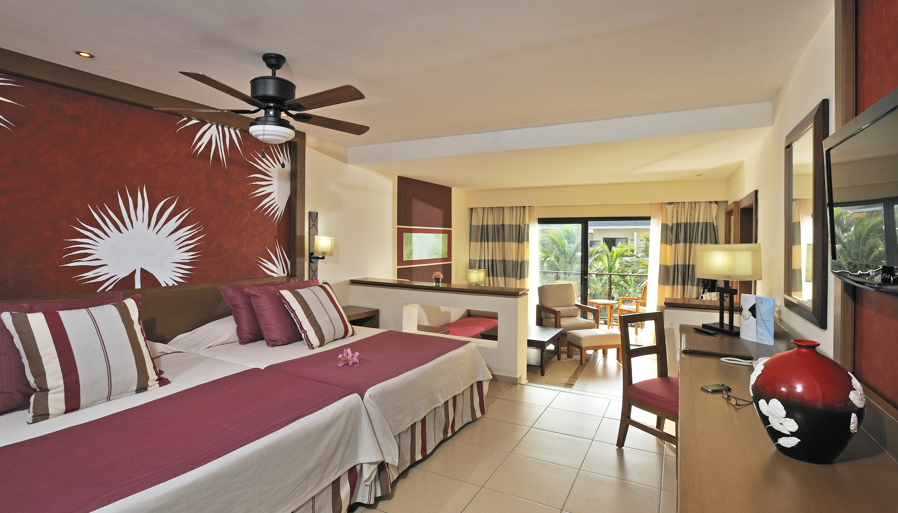 a room with two beds and a ceiling fan