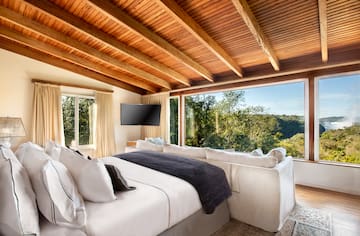 a bedroom with a large window and a large bed