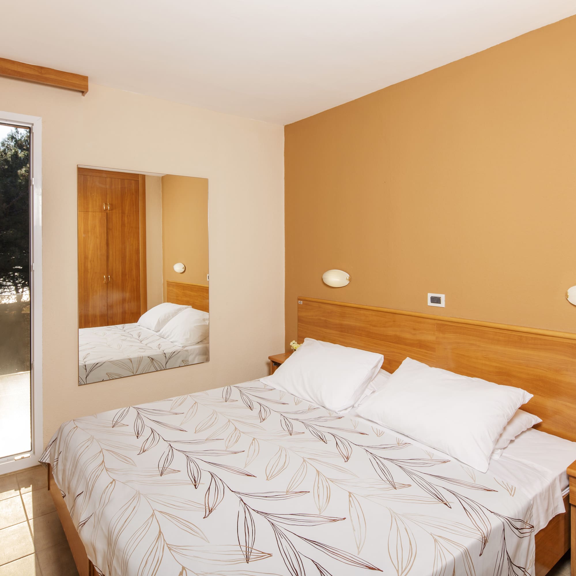 a bed with a mirror in a room