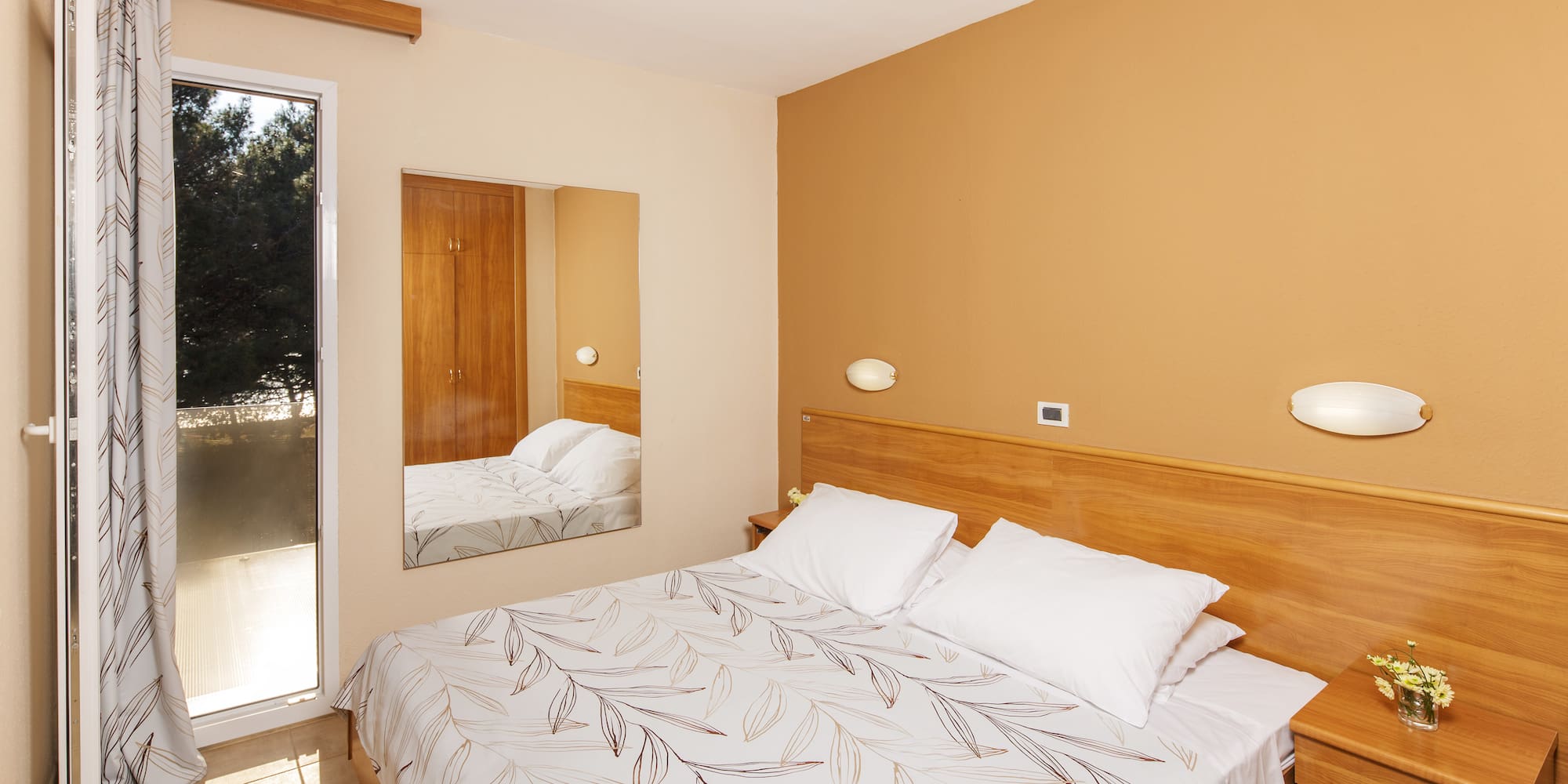 a bed with a mirror in a room