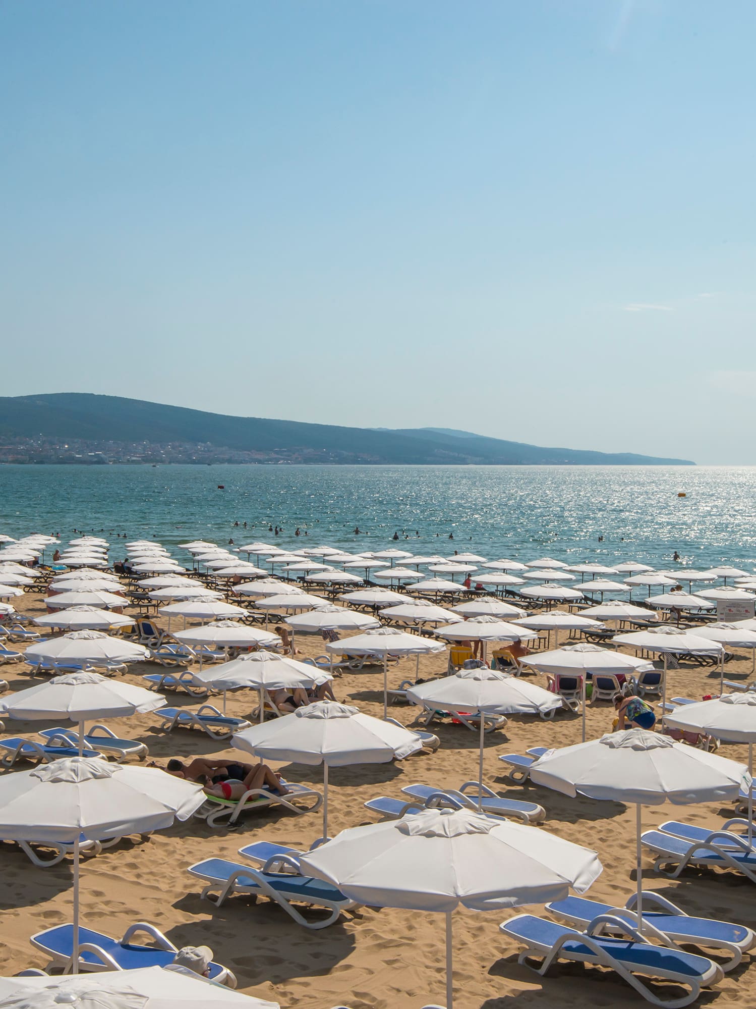 a beach with umbrellas and chairs