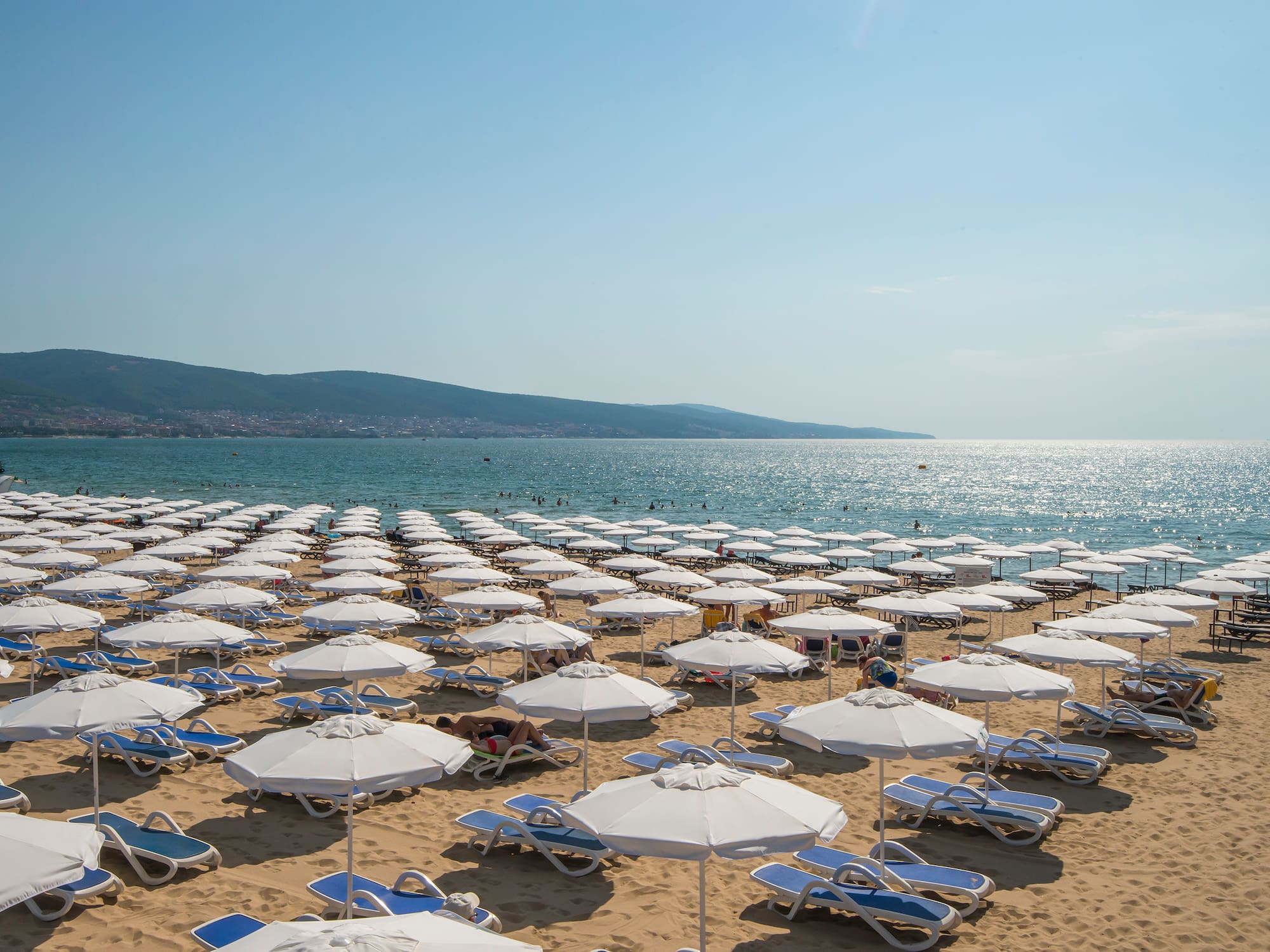 a beach with umbrellas and chairs