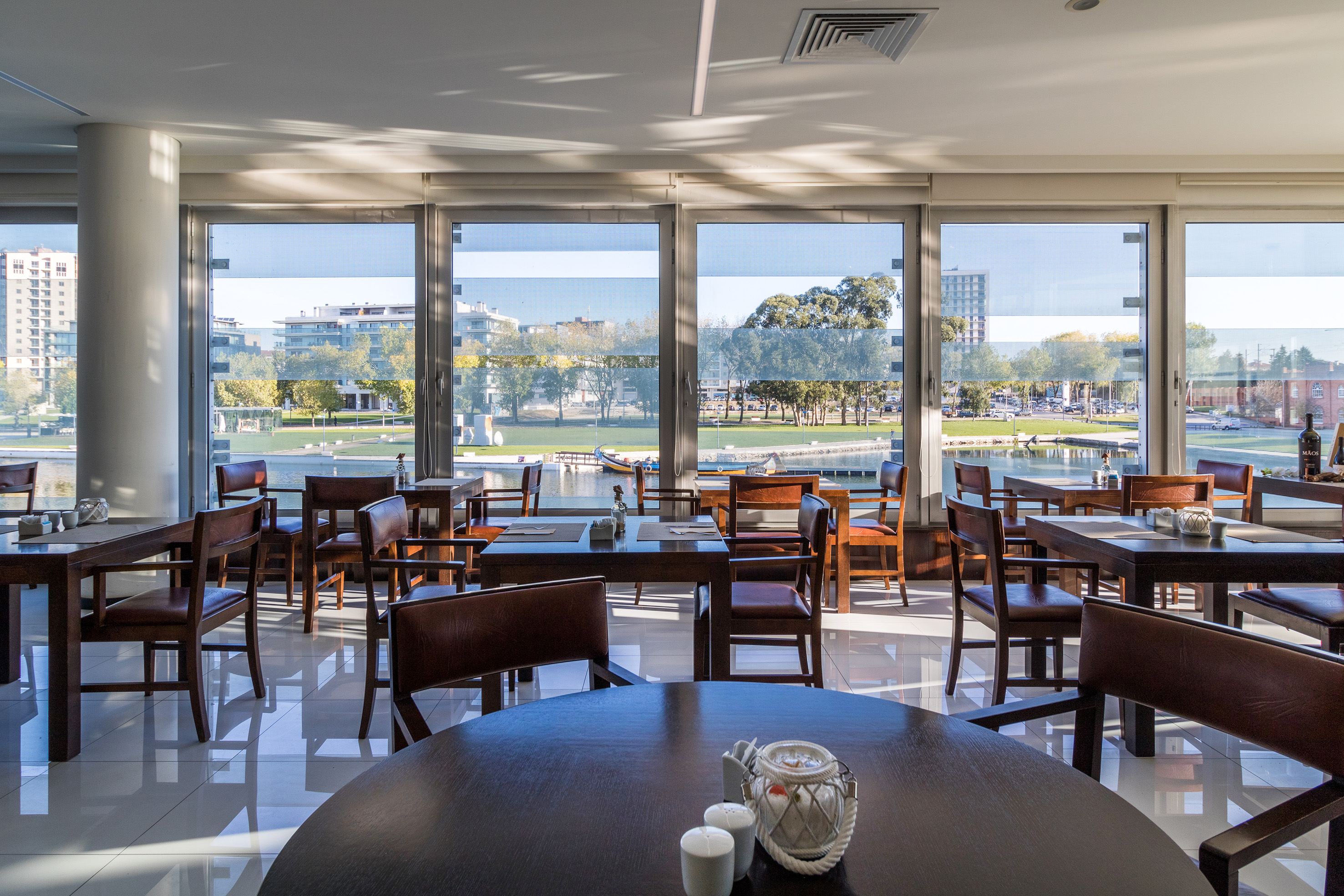 Bright modern restaurant with lake view through large windows.