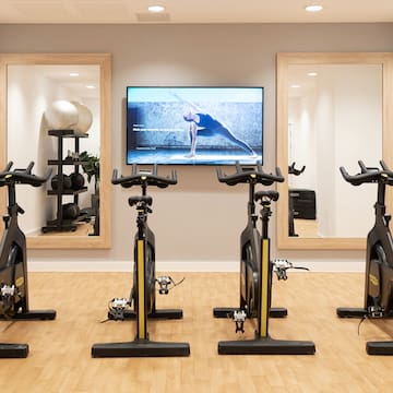 a room with exercise bikes and mirrors