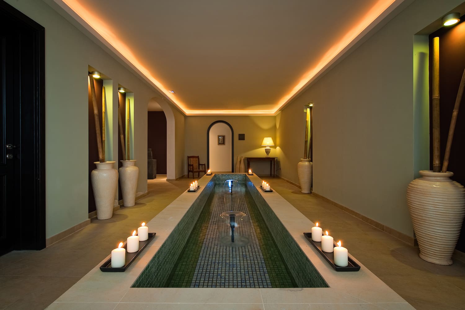 a long rectangular pool with candles in the middle
