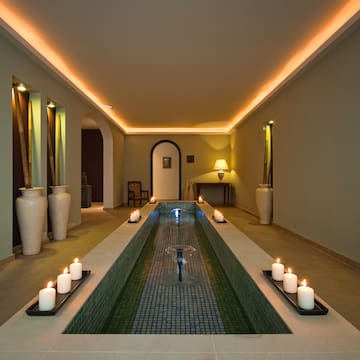 a long rectangular pool with candles in the middle