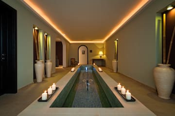 a long rectangular pool with candles in the middle