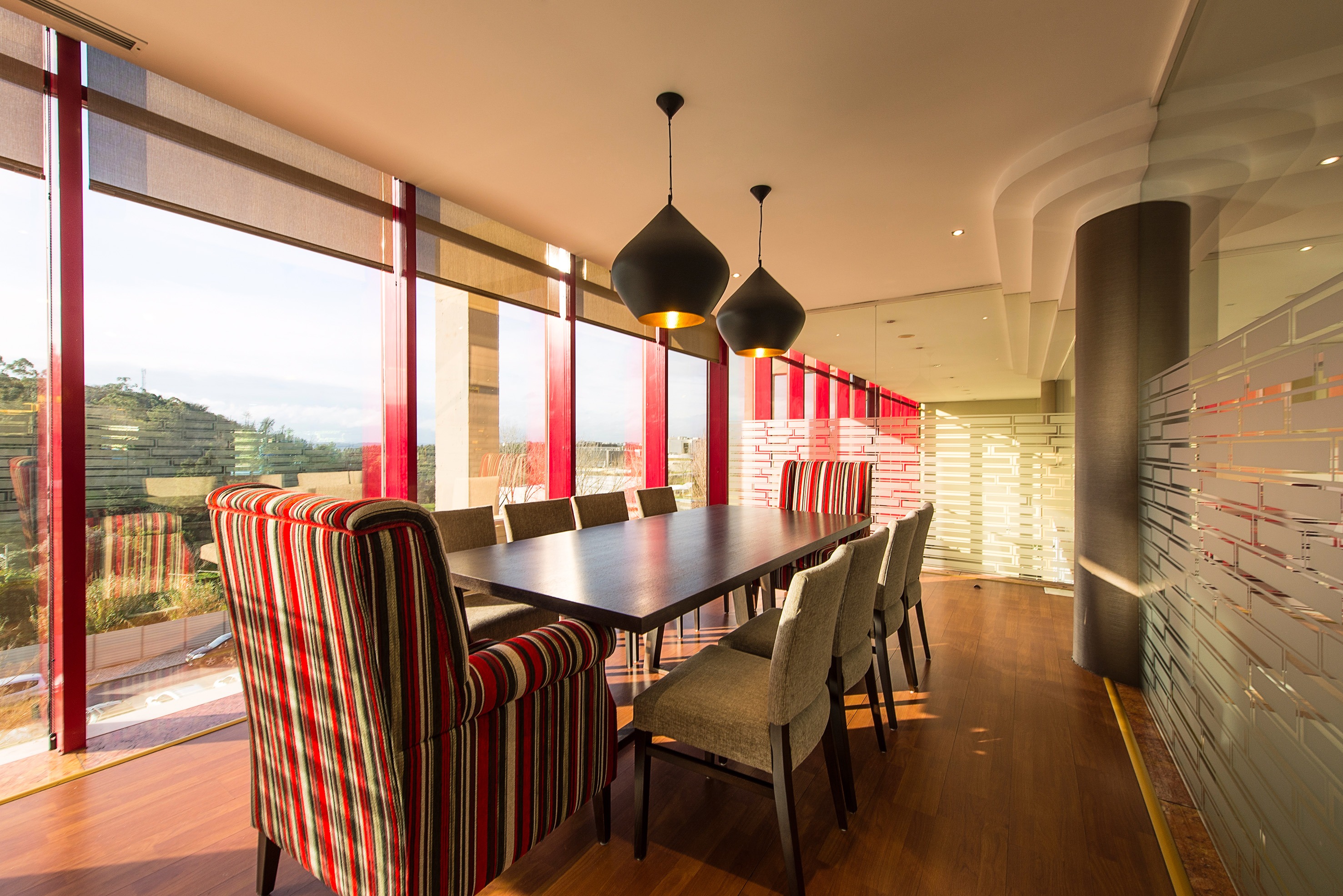 Elegant dining room with wood table, striped chairs, and large scenic windows.