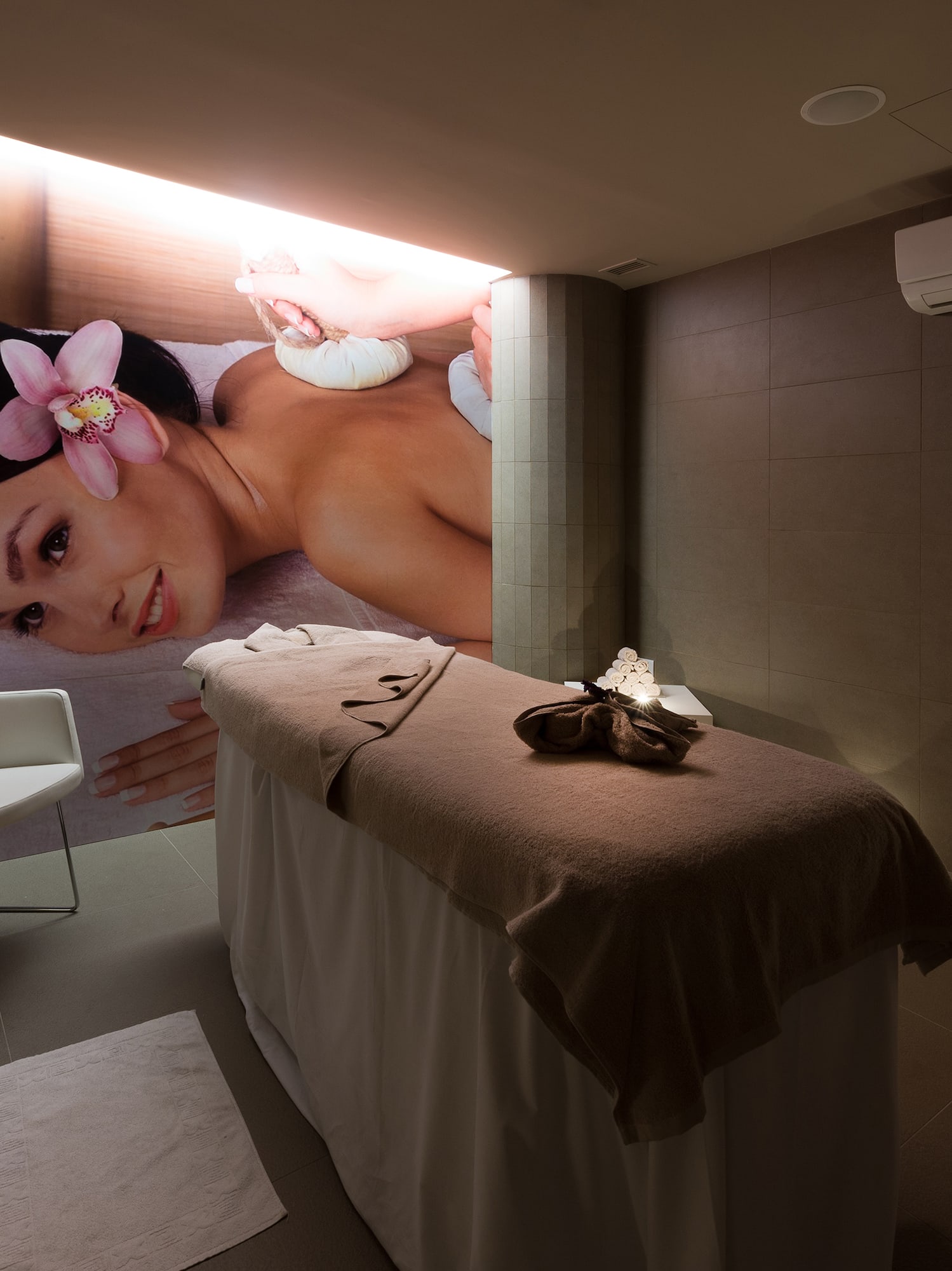 a room with a massage table and a chair