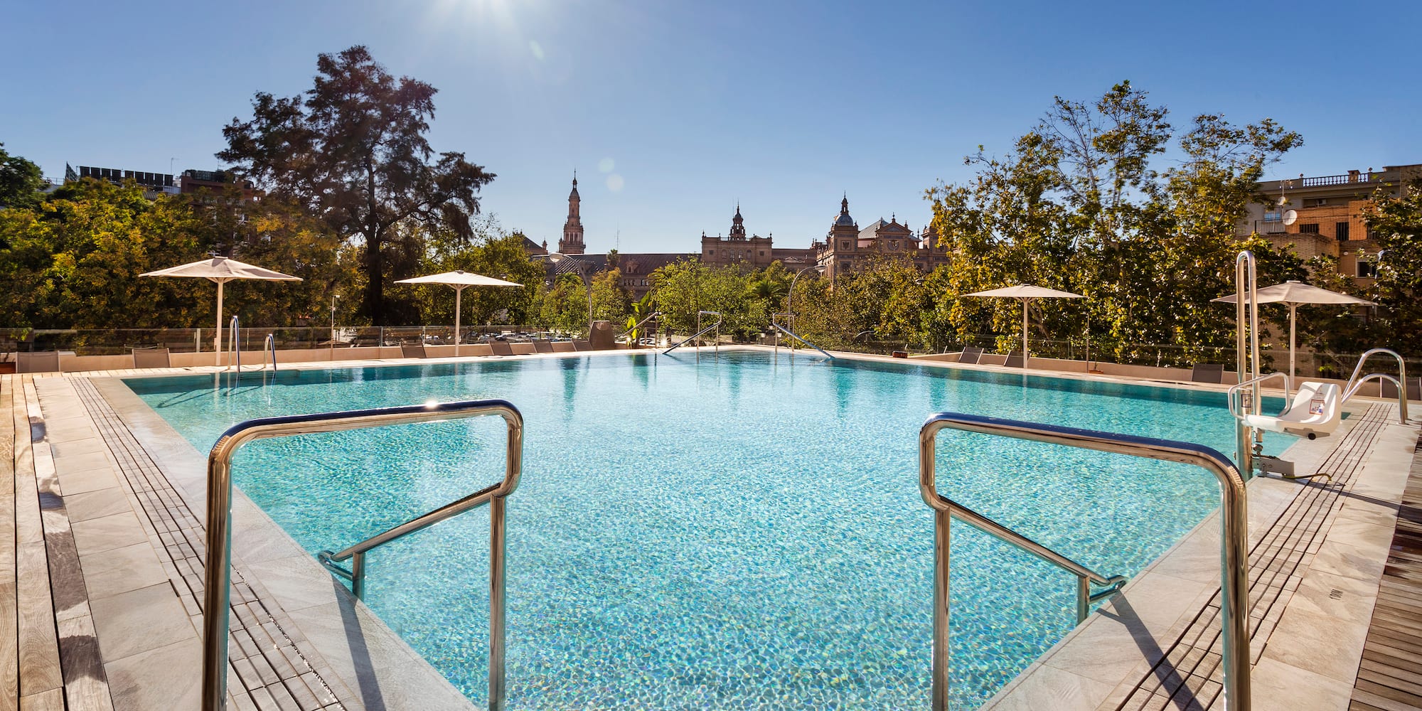 a swimming pool with umbrellas and a building in the background