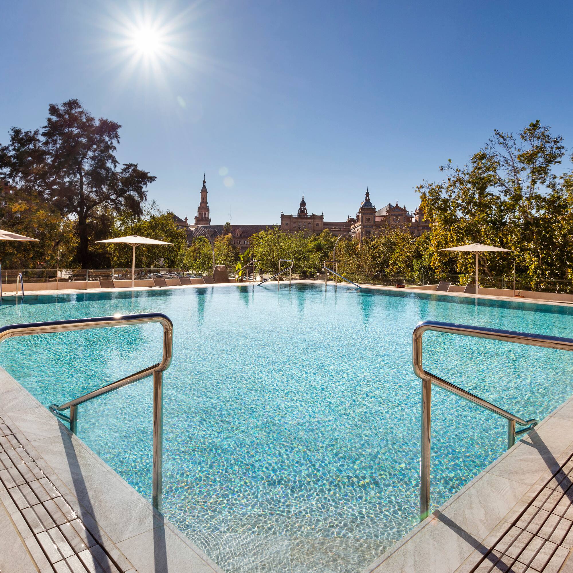 a swimming pool with umbrellas and a building in the background
