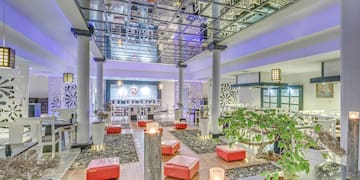 a room with a glass ceiling and a large area with red stools