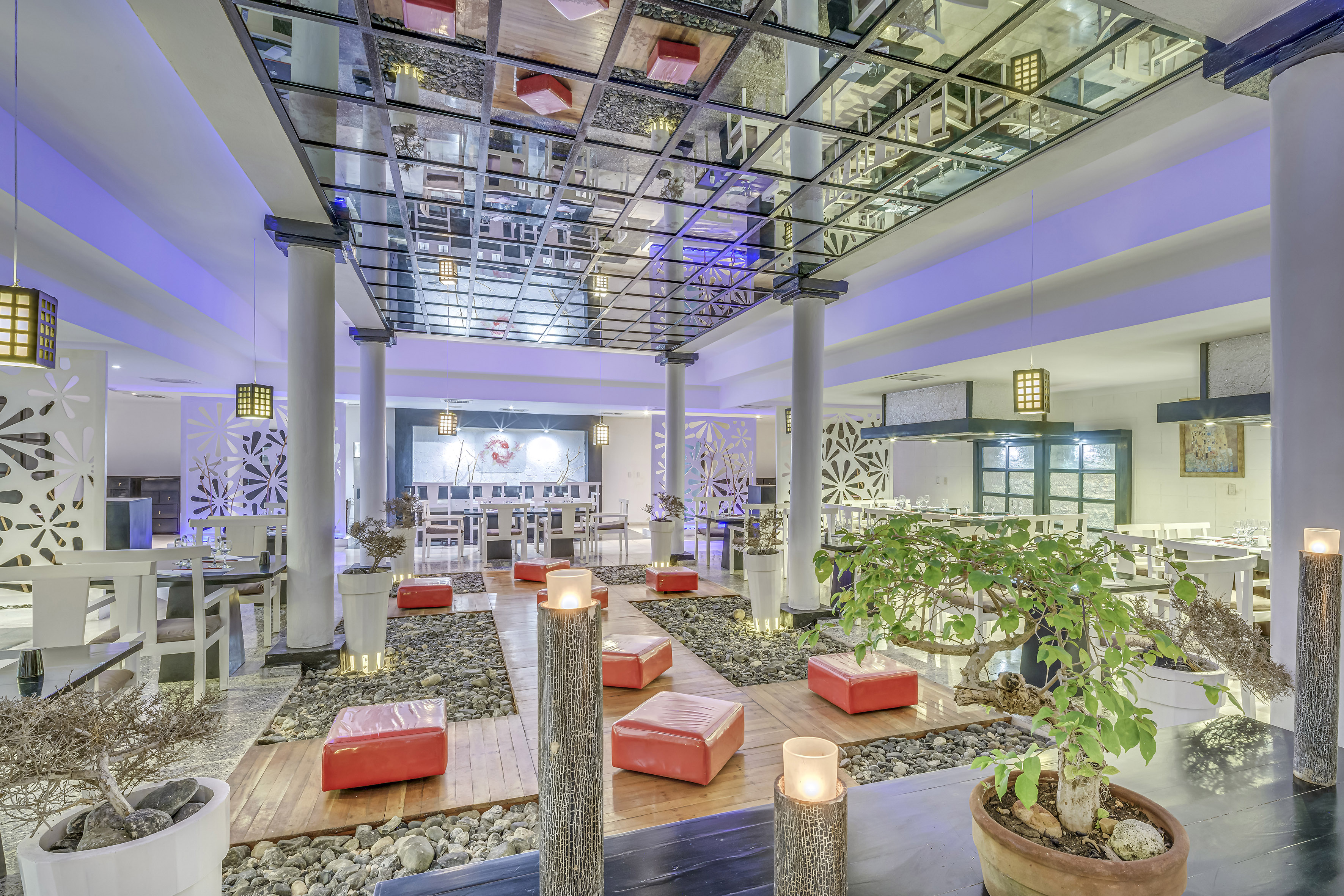 a room with a glass ceiling and a large area with red stools