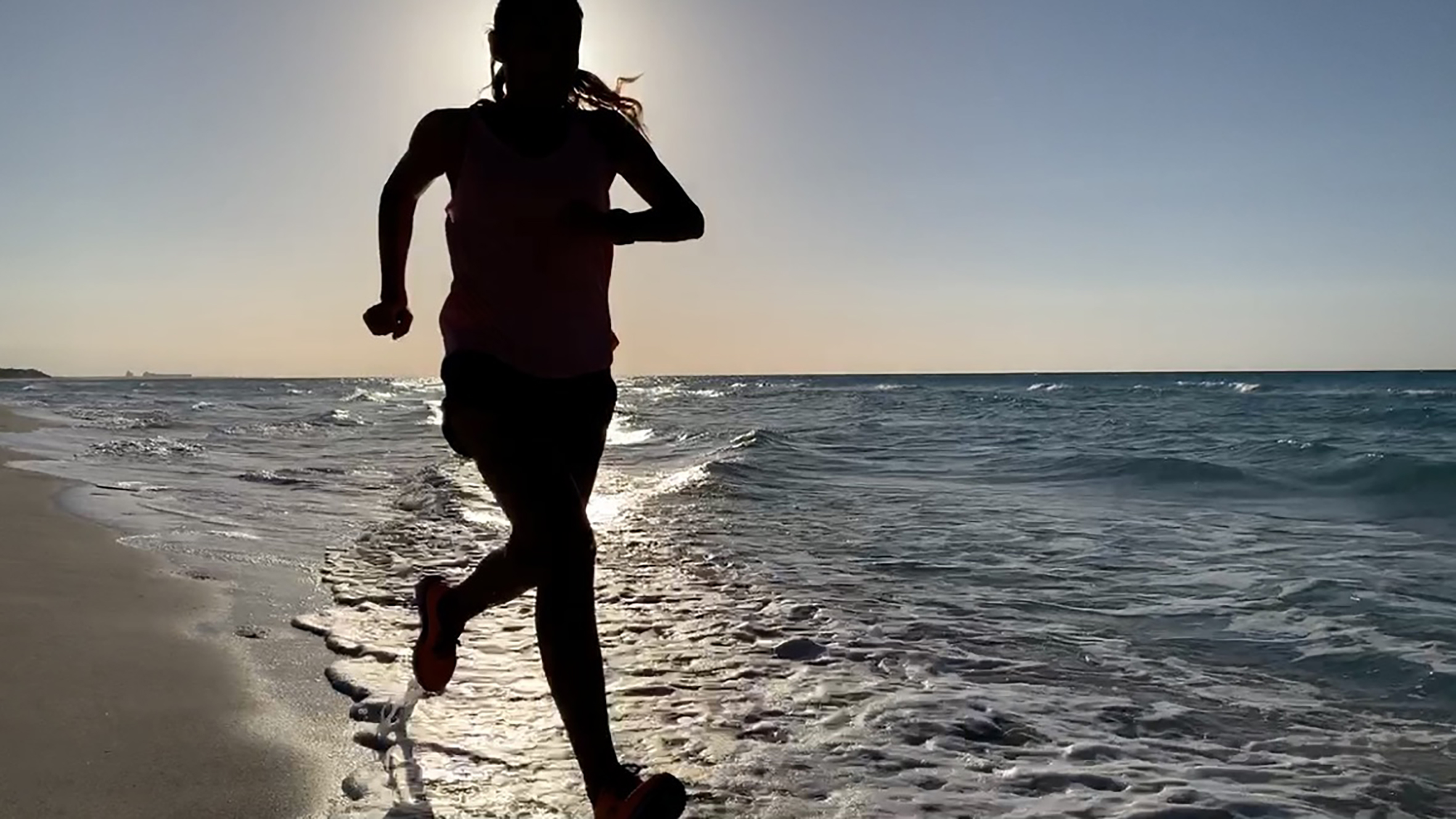 a woman running on a beach