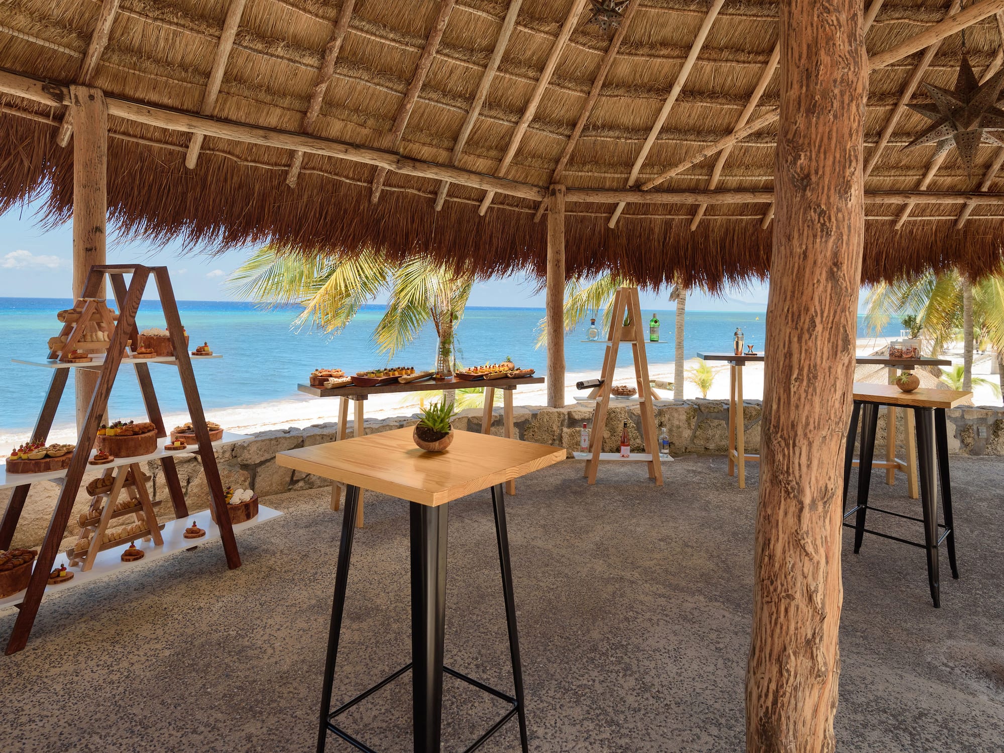 a table and chairs under a thatched roof